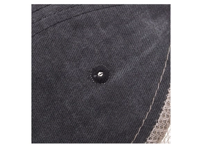 Detail shot of a dark grey cotton baseball cap showing the eyelet and stitched seam