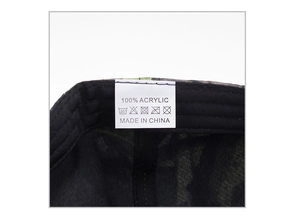 Detail view of the camouflage baseball cap interior featuring a 100% acrylic fabric label