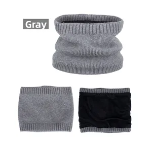 Detail of gray knitted infinity scarf showing soft black fleece lining for winter warmth