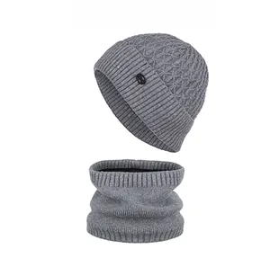 Detailed view of grey knitted beanie and neck warmer set with waffle texture and patch