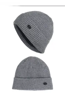 Gros plan du bonnet en tricot rayé gris foncé avec emblème de mode et texture côtelée
