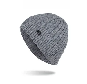 Detailed view of gray ribbed knit beanie featuring a small black circular logo patch
