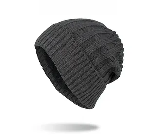 Close-up of thick grey knit beanie with ribbed texture and brown leather leaf logo patch
