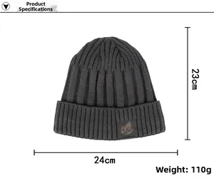 Detail of dark grey knit beanie featuring a brown leather maple leaf patch and ribbed texture
