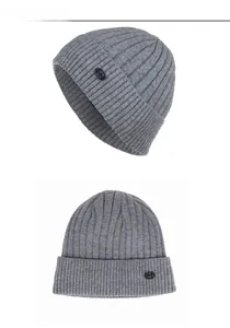 Vue détaillée de la texture en maille côtelée grise et de l'étiquette noire du bonnet