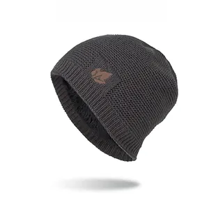 Detail of dark grey knit winter hat with thick plush lining and leaf logo patch