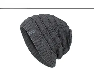 Dettaglio berretto in maglia grigio scuro con trama a scacchi ed etichetta FASHION