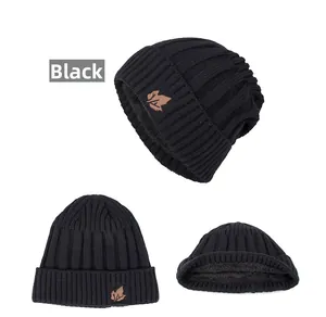 Detail showing the warm black thermal lining and brown maple leaf patch on the knit beanie
