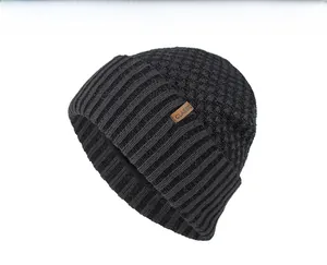Detail shot of black knit beanie featuring classic leather patch and ribbed pineapple texture