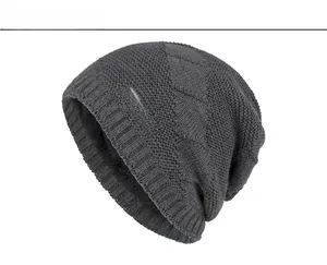 Close-up of dark grey knitted beanie with textured diamond pattern and Sports text logo