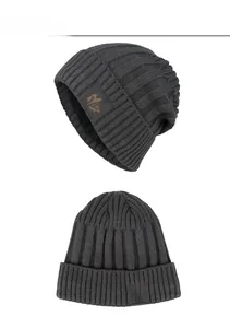 Detailed view of dark grey cable knit beanie with leather maple leaf patch decoration