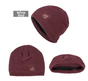 Macro view of wine red knitted beanie with warm fleece lining and leaf patch detail