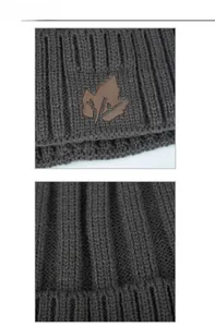 Macro detail of dark grey knit beanie featuring vertical ribbing and maple leaf leather patch