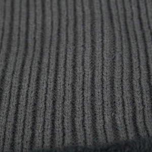 Gros plan sur la texture en tricot côtelé gris foncé d'un cache-col d'hiver
