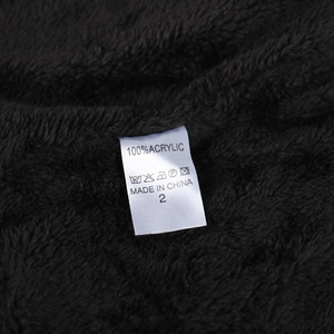 Close-up of black knit beanie with 100% acrylic label and soft plush fleece texture