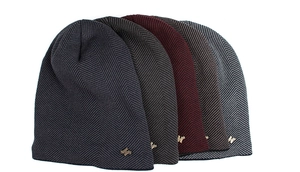 Detail of chevron knit beanies in navy and burgundy with gold metal branding plates
