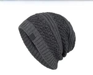 Detail showing dark grey knitted beanie texture with a red snowflake cloth label patch