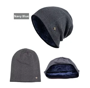 Detail of navy blue knitted beanie with plush fleece lining and gold metal H-logo