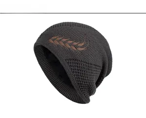 Detail of dark grey knit beanie featuring warm fleece lining and wheat embroidery