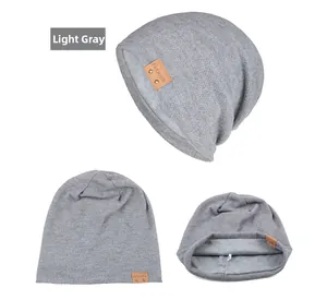 Detail einer hellgrauen Beanie mit braunem Leder-Patch und weichem Innenfutter für Damen
