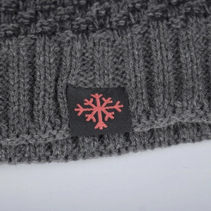 Winter dark grey knit beanie featuring a red snowflake label and ribbed cuff detail