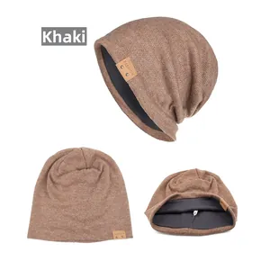 Detailansicht der khakifarbenen Strickmütze mit braunem Lederetikett und grauem Innenfutter