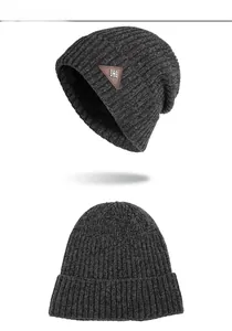 Detail of charcoal grey ribbed knit beanie with leather snowflake patch for winter