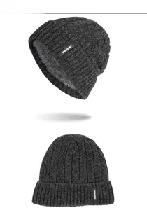 Detailed view of dark grey cable knit hat with thick fleece lining and leather logo tag