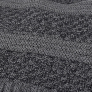 Close-up of deep grey knit beanie with intricate textured patterns and thick soft fiber