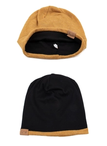 Detail einer senfgelben Beanie mit Lederetikett und weicher, dicker Strickstruktur