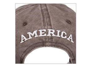 Dettaglio del ricamo AMERICA bianco sul retro di un cappello da baseball in cotone marrone
