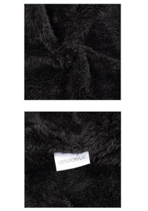Macro view of plush faux fur texture and 100% acrylic care label on a black scarf