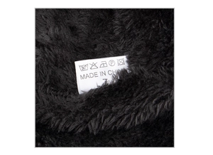 Detailed macro view of black fleece lining texture with care label and washing symbols