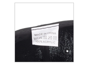 Detail showing the 100% acrylic fabric material label and care tag inside the baseball cap