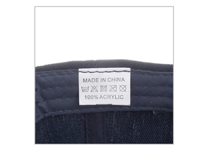 Dettaglio dell'etichetta 100% acrilico e istruzioni per la cura sulla cuffia blu navy