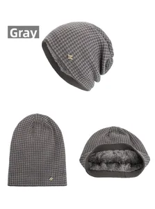 Detail of gray knitted beanie with plush lining and a decorative gold metal logo