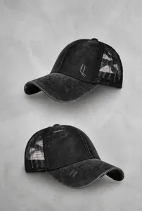 Detail of vintage washed black baseball cap with mesh back and distressed frayed edges