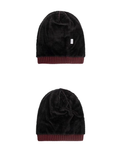 Detail of 100% acrylic knitted hat featuring soft black faux fur lining and red rib trim