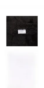 Close-up of soft black chenille fabric texture and 100% acrylic material label details