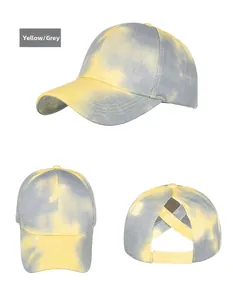 Detail view of yellow and grey tie-dye baseball cap with criss-cross ponytail hole design