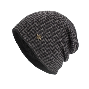 Winter knit beanie hat with black and grey houndstooth pattern and metal logo badge