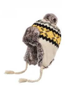 Detail of beige winter trapper hat featuring geometric patterns and plush faux fur trim