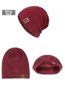 Detail der weinroten Waffelstrickmütze mit dickem Fleecefutter und braunem Lederetikett