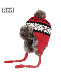 Detail of red winter knit hat with earflaps, snowflake patterns and faux fur lining