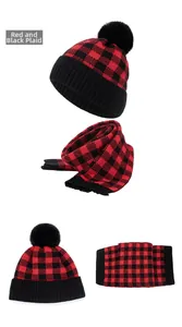 Detail of red and black buffalo plaid knitted winter hat and scarf set with soft texture
