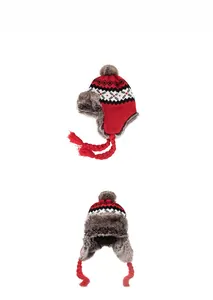 Close-up of red winter trapper hat with Nordic patterns and gray faux fur lining details