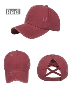 Detailed macro view of distressed burgundy cotton baseball cap with elastic criss-cross back