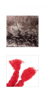 Detail view of red chunky knit fabric with tassels and soft faux fox fur trim