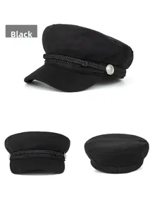 Detail view of black nautical baker boy hat with braided cord and silver anchor buttons