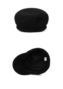 Detail showing black newsboy cap material composition on white label with inner lining